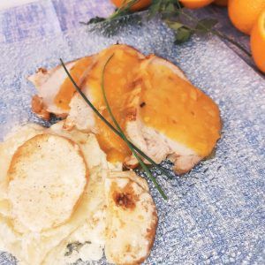 Lomo de cerdo asado en salsa de naranja con graten de papas y parmesano