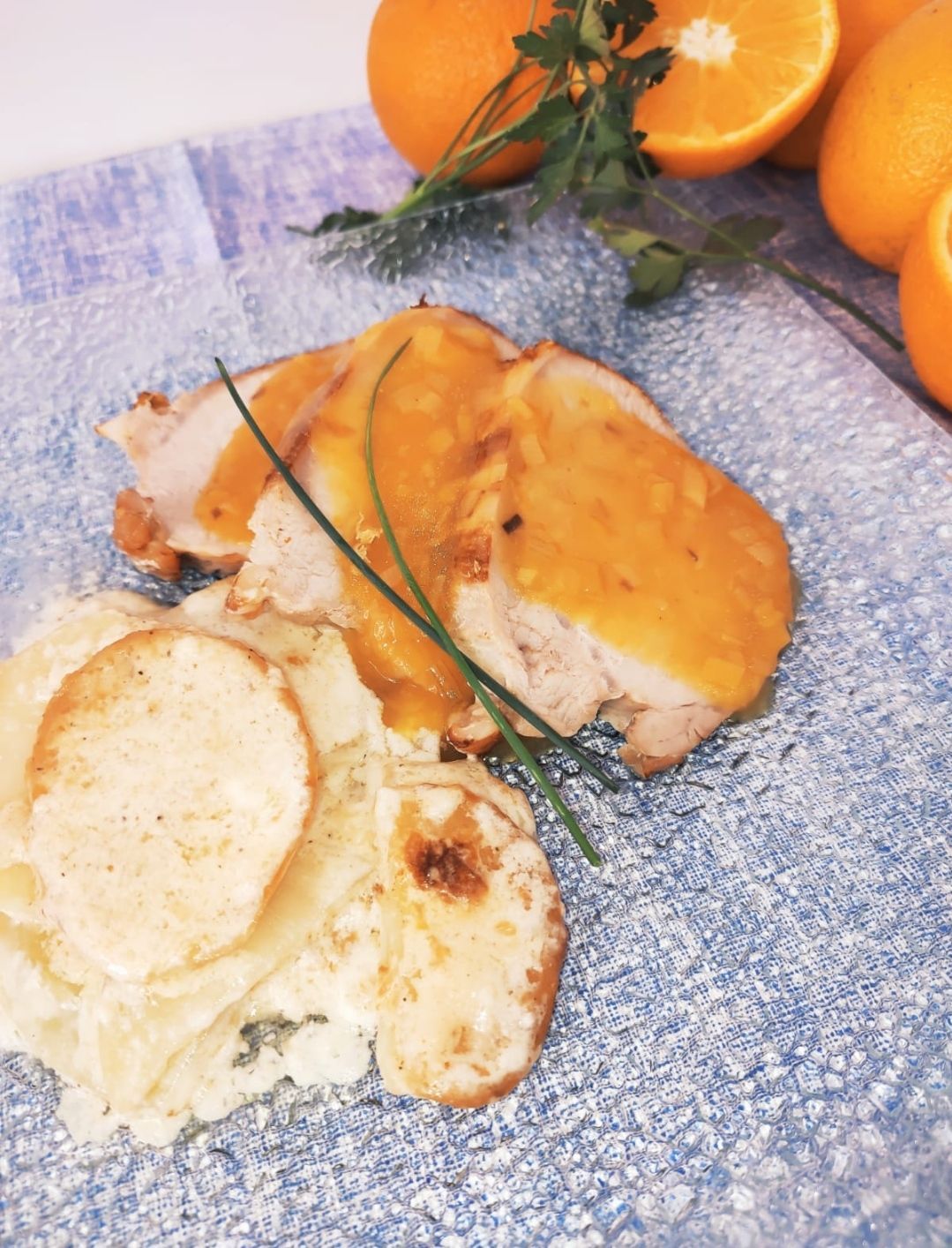 Lomo de cerdo asado en salsa de naranja con graten de papas y parmesano