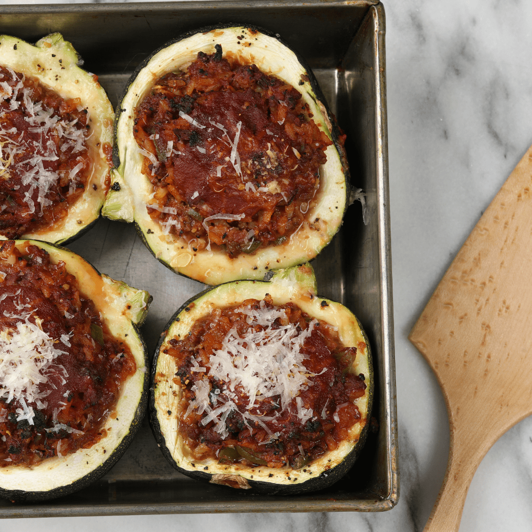Calabacines rellenos de carrilleras de cerdo, queso parmesano y pisto de verdura.