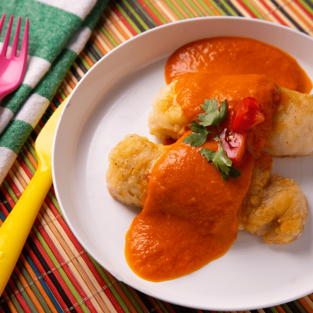 Merluza rebozada con salsa de tomate y puré de papas